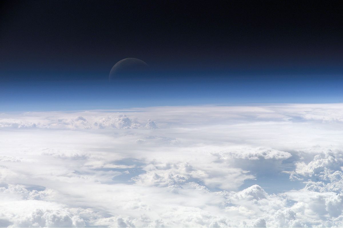 View of the crescent moon through the top of the earth's atmosphere, as seen from the International Space Station.
