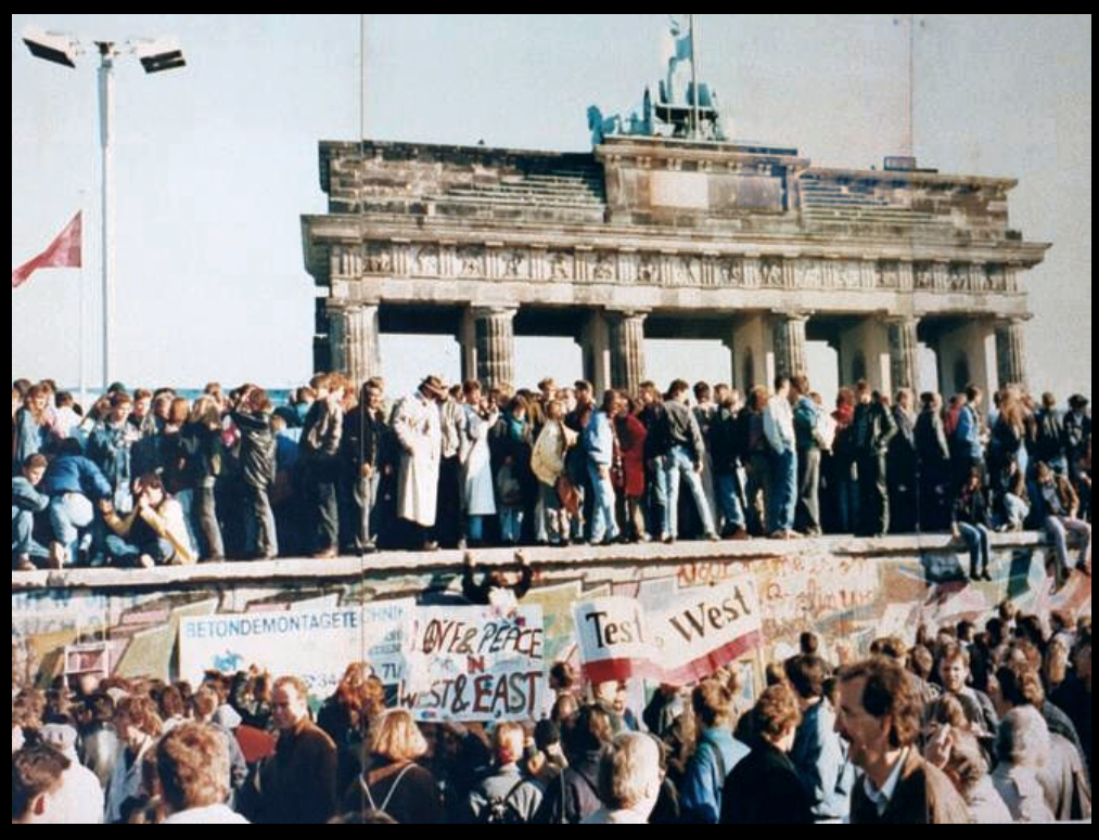 Germans stand on top of the Berlin Wall at the Brandenburg Gate days before it was torn down in 1989.