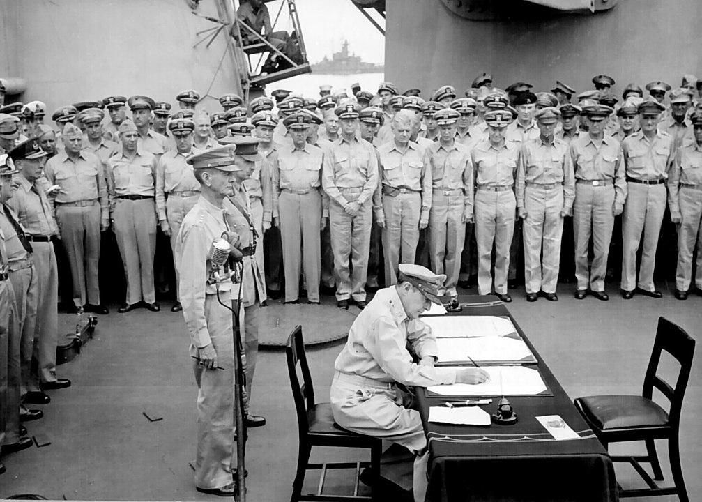General Douglas MacArthur signs the Japanese Instrument of Surrender aboard the USS Missouri.